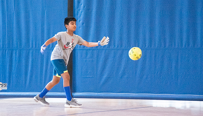 boy playing soccer in gym
