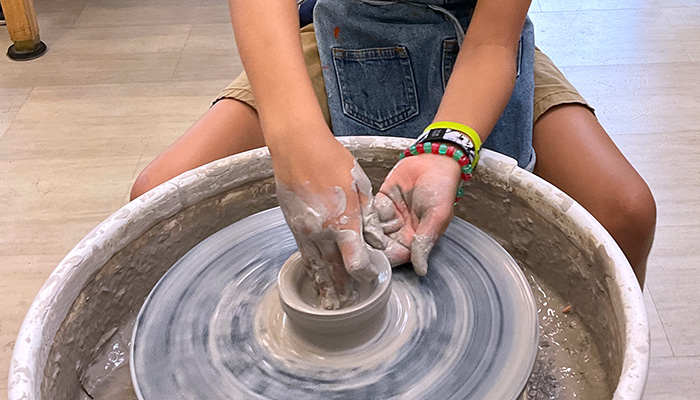 student using potters wheel