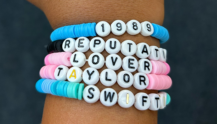 girl's arm featuring Taylor Swift bracelet