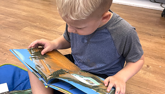 young boy reading book